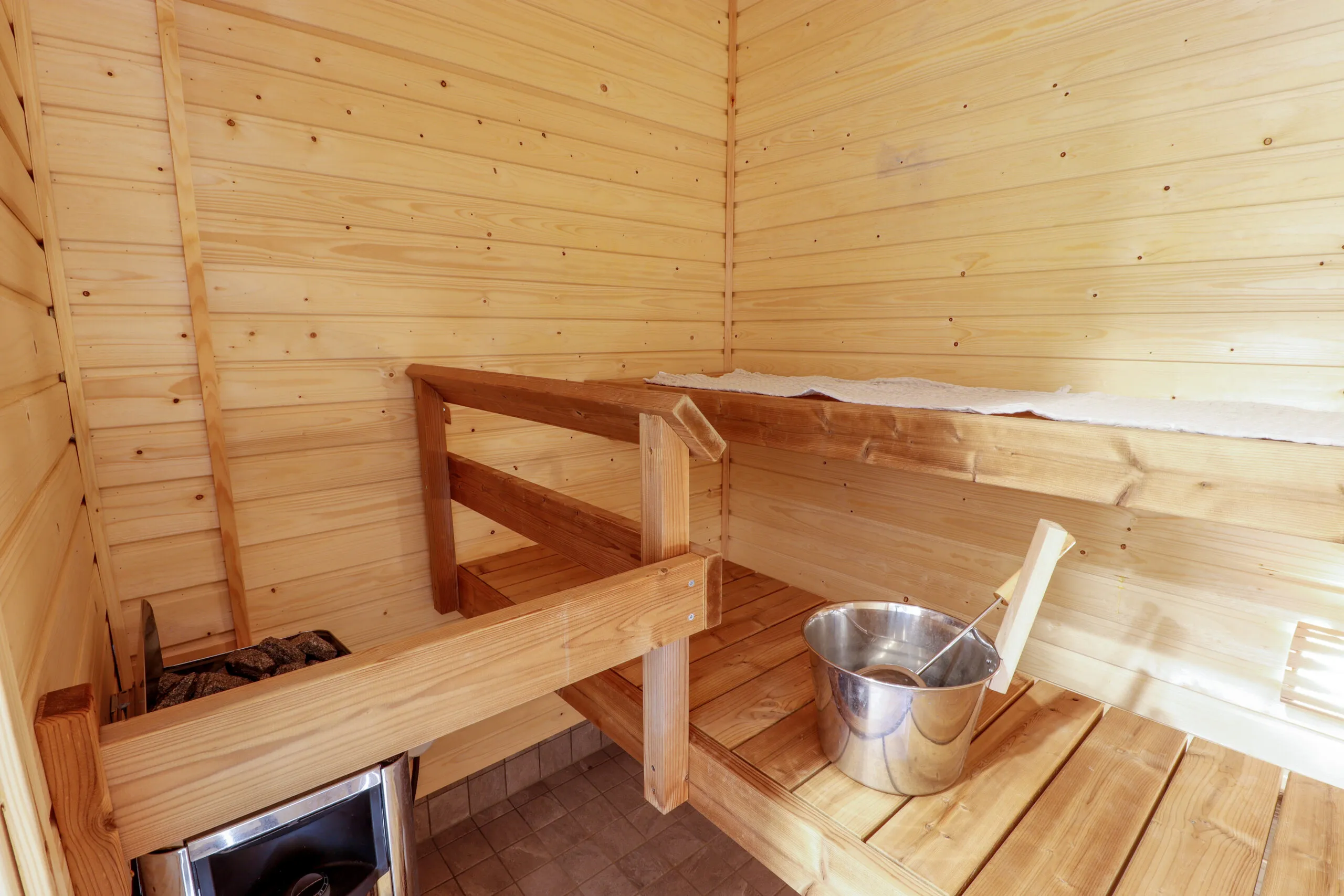 Asunnon sauna, vaalea paneelointi, kiulu ja kauha